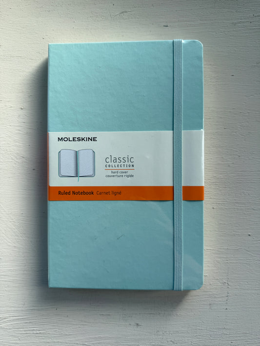 Moleskine Classic hard cover ruled notebook with cream pages, designed for writing and note-taking.
