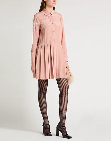 Red Valentino blush shirt dress hanging on a wooden hanger, showcasing its soft fabric and classic collar details.