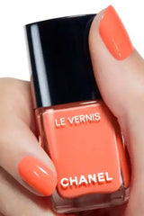 Chanel Vernis Nail Colour bottles in various shades, featuring vibrant coral and other colors, in a beauty product display.