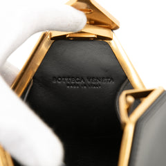 Black Bottega Veneta calfskin pyramid handbag with structured design and signature woven pattern, stylish and luxurious accessory.
