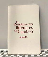 Chanel lined notebook for home use displaying elegant black cover with Chanel logo and lined pages inside.