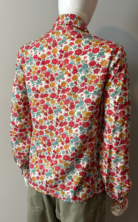 Loretta Caponi floral blouse in size small, featuring delicate floral print and lightweight fabric, displayed on a hanger.