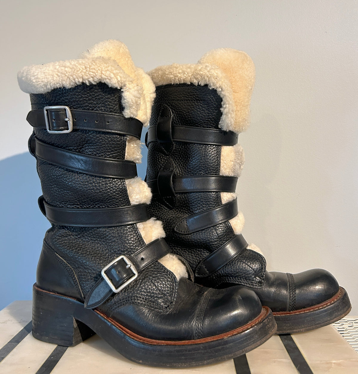 Coach shearling moto boots in size 6.5, featuring a rugged design with shearling lining and sturdy leather construction.