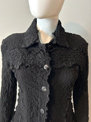 Issey Miyake blazer in size 6, featuring a tailored fit with sleek fabric, displayed on a hanger.