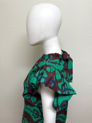 Ulla Johnson Iren silk blouse in a light, flowy fabric with a relaxed fit and elegant design, displayed on a hanger.