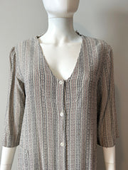 Raquel Allegra grey stripe duster dress in size XS hanging on a clothing rack with a flowing, lightweight fabric.