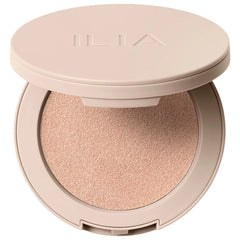 Ilia Lightshift Weightless Silky Cream Highlighter with a shimmering glow, shown in a sleek compact with a reflective finish.