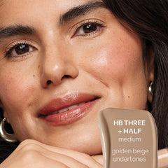 Saie Hydrabeam hydrating under eye brightener in multiple shades, close-up view showing creamy texture and packaging.
