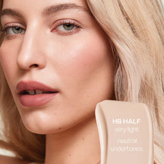 Saie Hydrabeam under eye brightener in multiple shades, showing a close-up of the creamy concealer's smooth texture and natural finish.