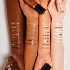 Too Faced Born This Way Super Coverage Concealer in various shades, showcasing the product tube with a clean, minimalist background.
